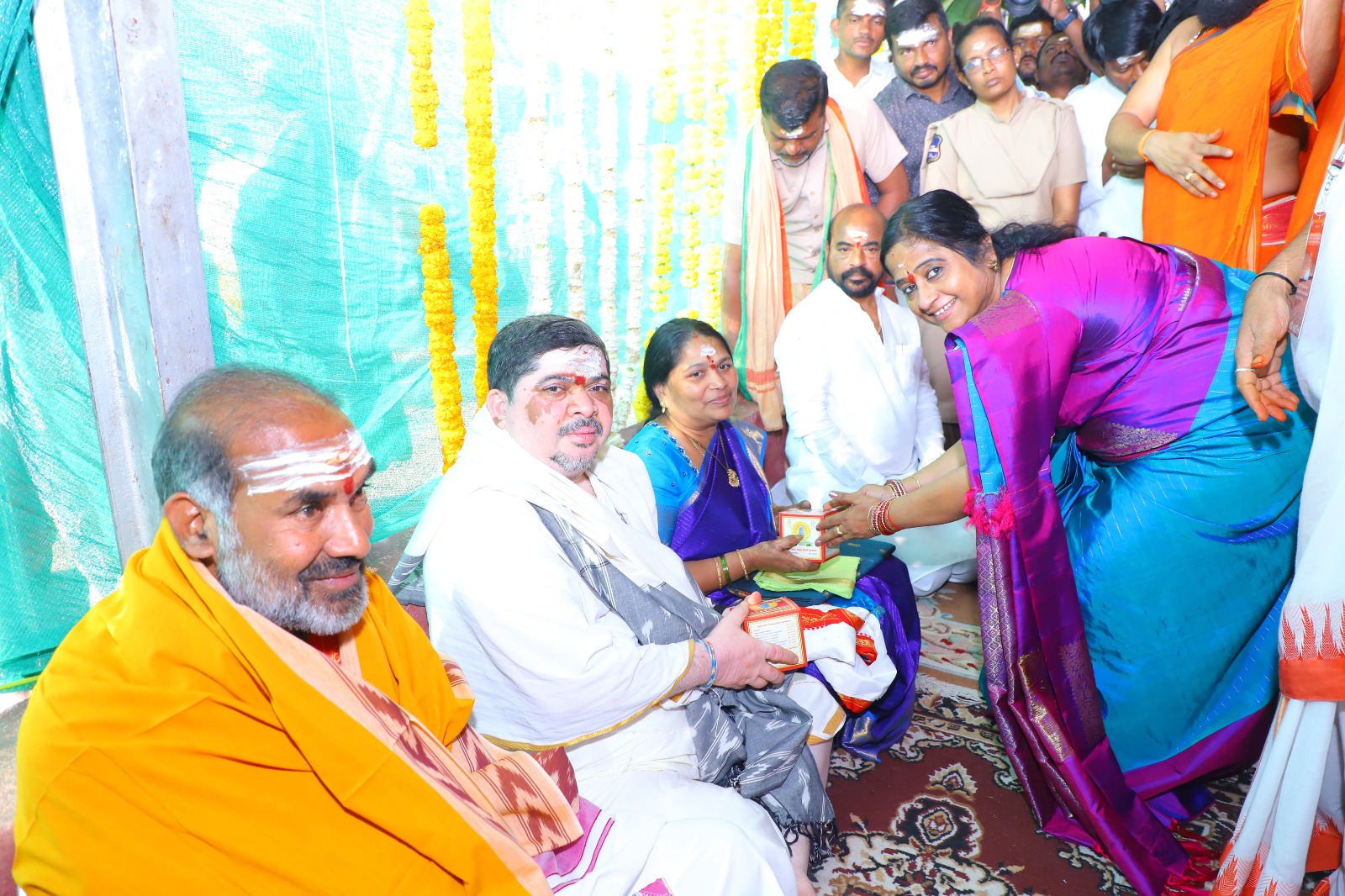 మంత్రి తీర్థ ప్రసాదాలు అందజేస్తున్న ఆలయ అధికారులు